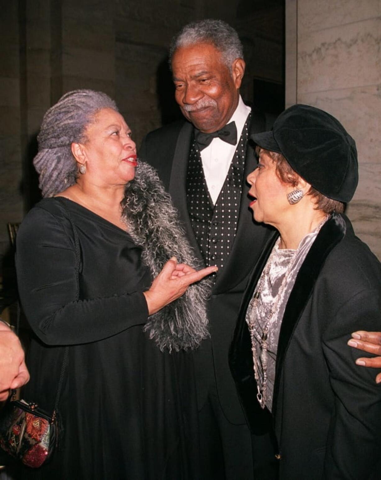 FILE - In this Feb. 17, 2001 file photo, Nobel Prize winning writer Toni Morrison, left, shares a moment with actors and activist Ossie Davis, center, and his wife Ruby Dee during a 70th birthday tribute for Morrison hosted by the Toni Morrison Society and Alfred A. Knopf in New York. Morrison, a pioneer and reigning giant of modern literature whose imaginative power in “Beloved,” ‘’Song of Solomon” and other works transformed American letters by dramatizing the pursuit of freedom within the boundaries of race, has died at age 88. Publisher Alfred A. Knopf announced that Morrison died Monday, Aug. 5, 2019 at Montefiore Medical Center in New York.