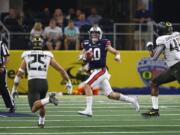 Auburn quarterback Bo Nix (10) looks to pass as Oregon safety Brady Breeze (25) and Oregon defensive end Gus Cumberlander (45) pursue during the first half of an NCAA college football game, Saturday, Aug. 31, 2019, in Arlington, Texas.