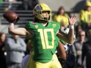 FILE - In this Dec. 31, 2018, file photo, Oregon quarterback Justin Herbert throws a pass during the first half of the Redbox Bowl NCAA college football game in Santa Clara, Calif. Herbert is among the top returning talents in the Pac-12, and the Ducks' hopes of league title contention in coach Mario Cristobal's second season could hinge on whether his quarterback improves on last year's 3,000-yard campaign.