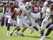 Portland State quarterback Davis Alexander tries to get away from Arkansas defender Joe Foucha as he scrambles out of the pocket in the first half of an NCAA college football game, Saturday, Aug. 31, 2019 in Fayetteville, Ark.