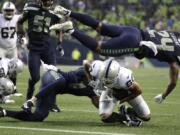 Seattle Seahawks defensive back Shalom Luani (24) flies over Oakland Raiders wide receiver Marcell Ateman (88) after Ateman made a catch during the first half of an NFL football preseason game Thursday, Aug. 29, 2019, in Seattle.