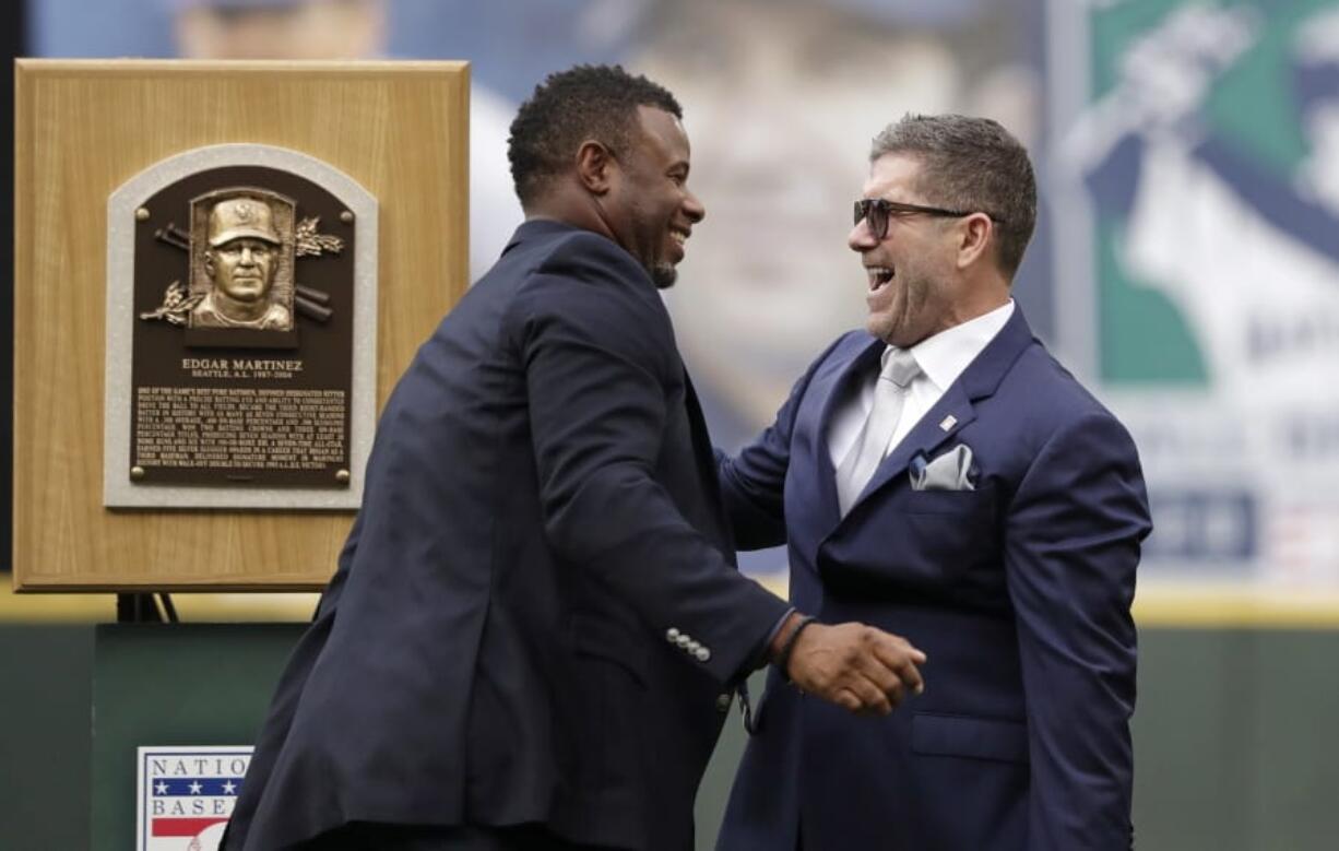 Former Seattle Mariners designated hitter Edgar Martinez, right, is greeted by former teammate and fellow Hall of Famer Ken Griffey Jr. while Martinez was being honored for his recent induction into the Baseball Hall of Fame, before a game between the Mariners and the Tampa Bay Rays on Saturday, in Seattle.