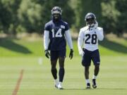 Seattle Seahawks wide receiver DK Metcalf (14) and cornerback Ugo Amadi (28) walk on the field following NFL football training camp, Monday, Aug. 5, 2019, in Renton, Wash. (AP Photo/Ted S.