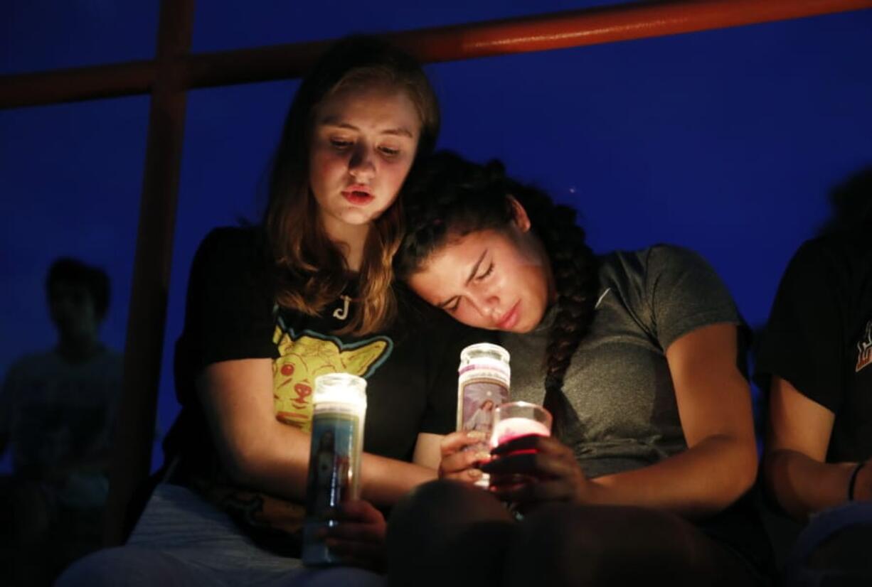 Melody Stout and Hannah Payan comfort each other during a vigil for victims of the shooting that occurred earlier in the day at a shopping center, Saturday, Aug. 3, 2019, in El Paso, Texas.