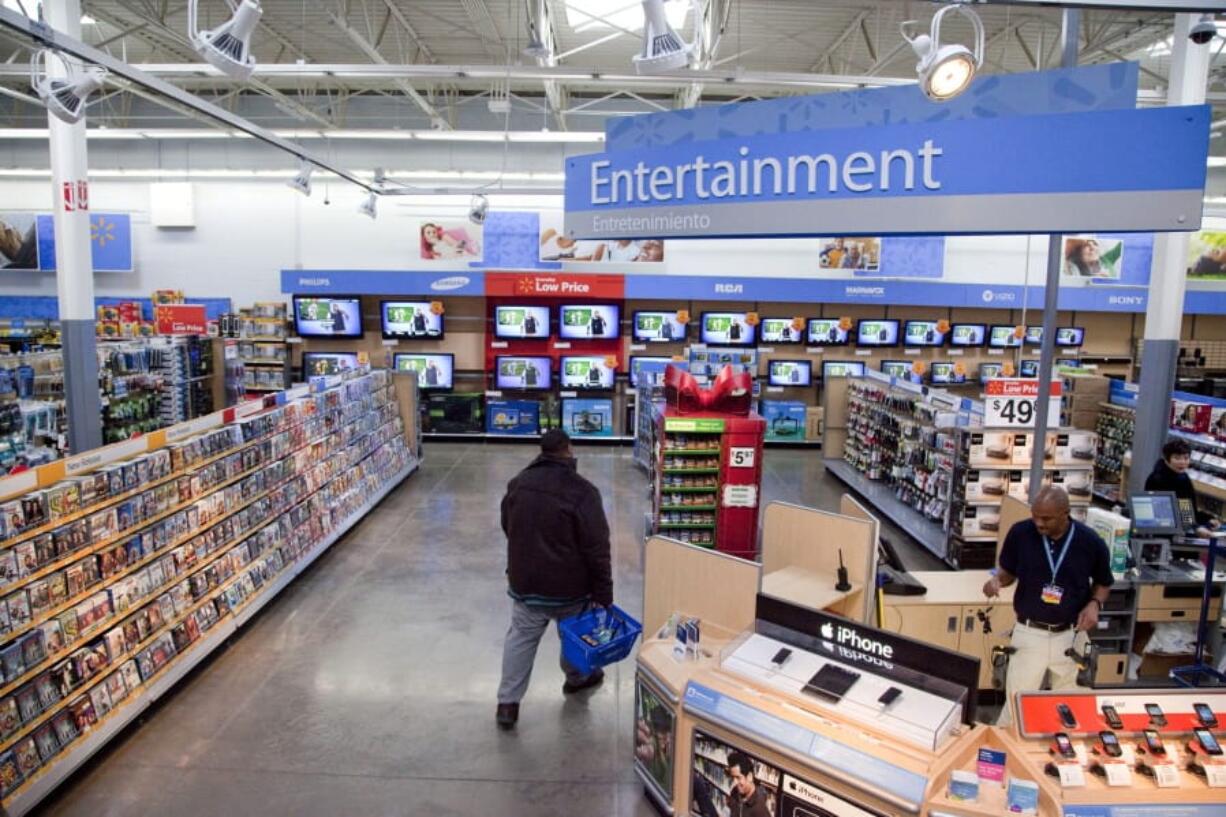 FILE = In this Dec. 15, 2010 file photo, a view of the entertainment section of a Wal-Mart store is seen in Alexandria, Va. Walmart is taking down all signs and displays from its stores that depict violence, following a mass shooting at its El Paso, Texas location that left 22 people dead. The retailer, according to an internal memo, instructed employees to turn off or unplug any video game consoles that show violent games, as well as ensure that no movies depicting violence are playing in its electronics departments.