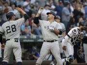 New York Yankees’ Austin Romine (28) congratulates Mike Ford on Ford’s two-run home run as Seattle Mariners catcher Omar Narvaez heads to the mound in the second inning of a baseball game Monday, Aug. 26, 2019, in Seattle.