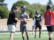 Hudson’s Bay’s Dylan Damos (grey shirt) talks with quarterbacks coach Tom Schroeder at practice Aug. 23. Damos started one game for the Eagles in 2018.