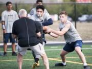 Seton Catholic quarterback Luke Pitzer reads the option as he fakes a handoff to running back Elijah Volk.