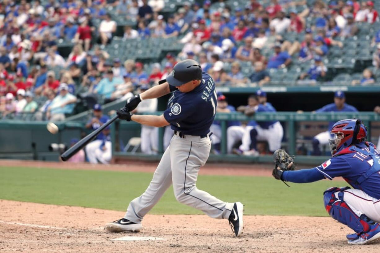 Seattle Mariners' Kyle Seager, left, connects for a three-run home run on a pitch from Texas Rangers reliever Taylor Guerrieri as catcher Jose Trevino, right, watches in the eighth inning of a baseball game in Arlington, Texas, Sunday, Sept. 1, 2019.