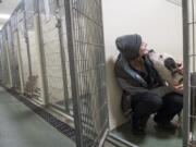 Animal care technician Tiarie West of La Center greets Dasher, a 4-year-old American Pit Bull, while feeding the animals Jan. 4 at the Humane Society for Southwest Washington. Battle Ground residents who find lost dogs can take them to the Humane Society.