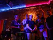 From left, Kelli Harrison, Bob Niehaus, Kelly Ravenscraft, Jennie Garcia and Alex Aivars pray during an Affirming Worship service Aug. 13 at Atmosphere Bar in Chicago.