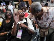 World War II veteran Lawrence Brooks, center, is greeted by a fellow church member Edith Francisco on Thursday as he celebrates his 110th birthday at the National World War II Museum in New Orleans. Brooks was born Sept. 12, 1909.