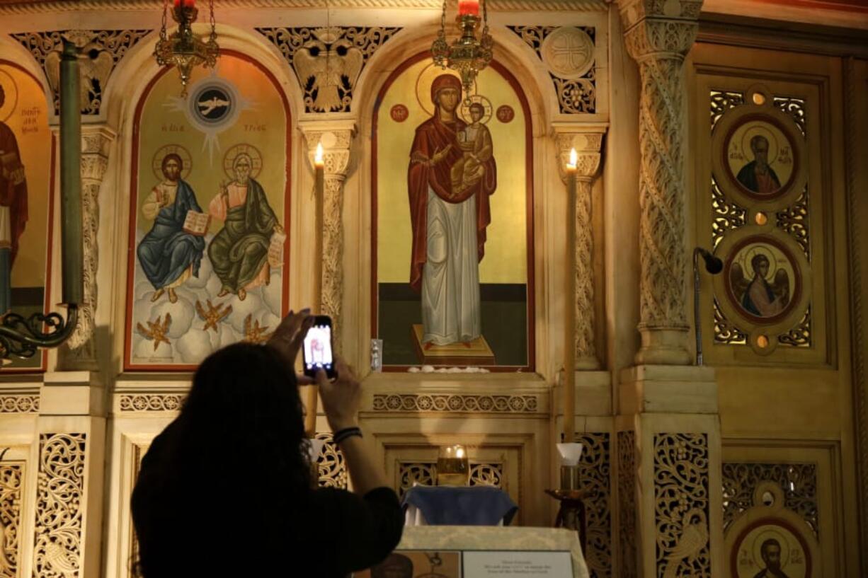 People flock to the painting of the Virgin Mary and take photos of what appears to be a liquid weeping from her eyes in Chicago’s Holy Trinity Greek Orthodox Church on Sept. 9, 2019.