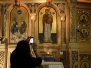 People flock to the painting of the Virgin Mary and take photos of what appears to be a liquid weeping from her eyes in Chicago’s Holy Trinity Greek Orthodox Church on Sept. 9, 2019.