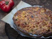 Tomatoes are roasted in the oven to remove most of their water, then layered in a crust with cheese, basil and cracker crumbs and spread with a cheese, pimento and mayo topping.