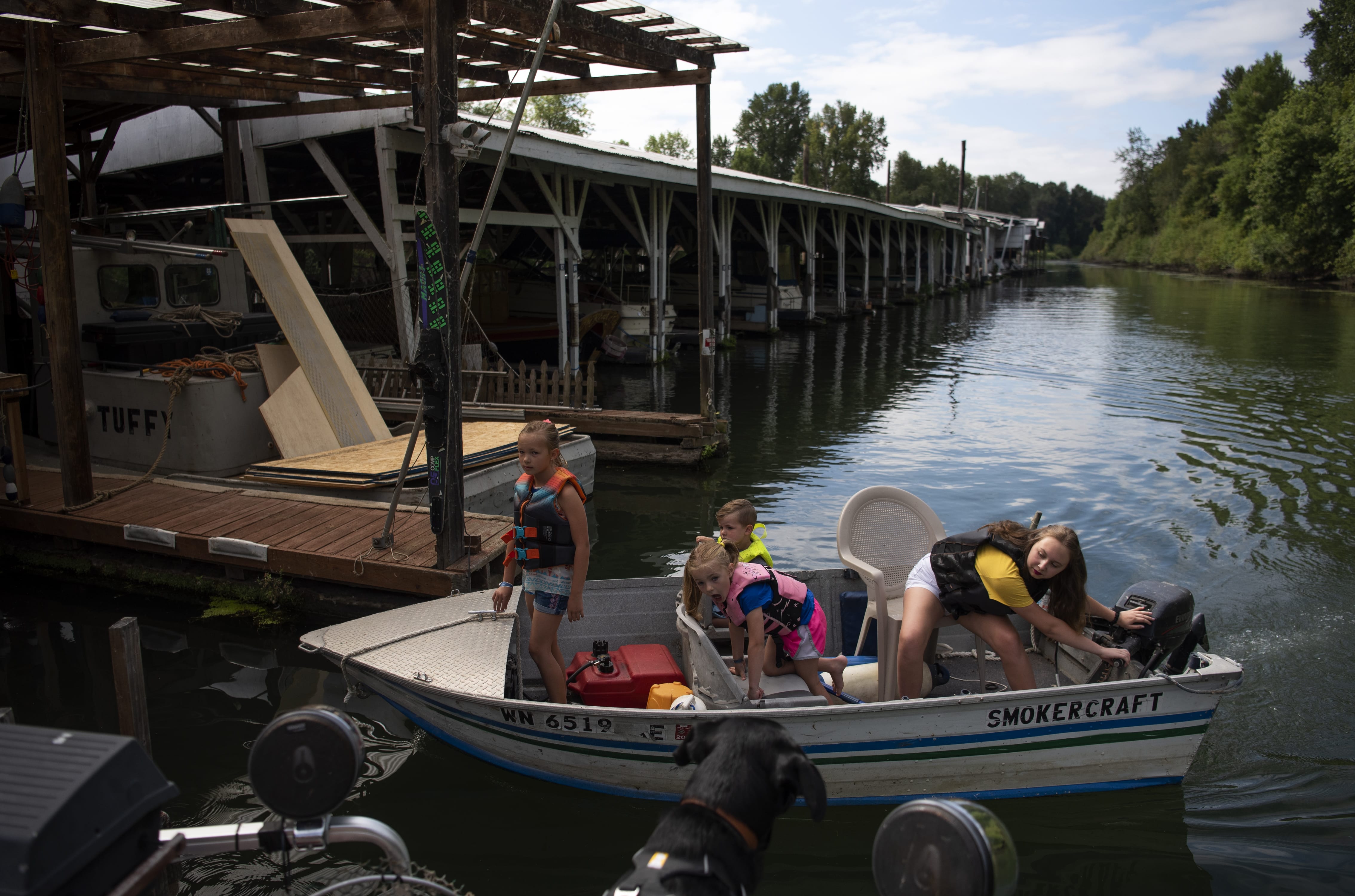 Siblings Peyton Colson, 8, left, Camden Colson, 3, back center, Haven Colson, 6, front center, and their cousin Rowan Hartle, 14, all of Vancouver, ride one of their grandparents’ boats back to the dock after taking it for a spin around at Kadow’s Marina in Vancouver last month.