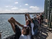 Attendees hold their hands up and recite the Serenity Prayer during the Hands Across the Bridge event on the I-5 bridge on Monday, September 2, 2019. This day marked the 19th anniversary of the event, in which people in recovery come together to share their stories and celebrate sobriety. More than 900 people walked from Esther Short Park out onto the bridge to meet the crowd walking from the Oregon side of the Columbia River.