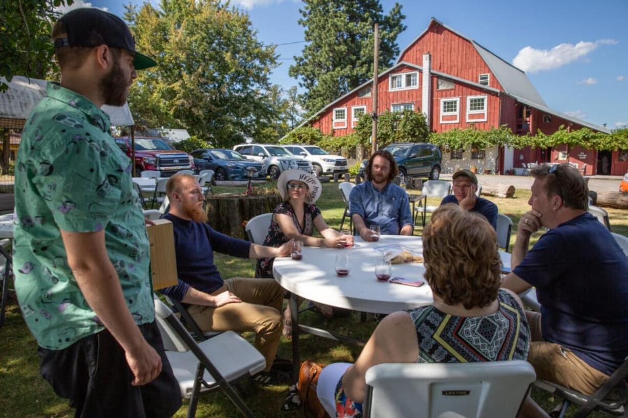 English Estate Winery tasting room manager Andrew Starr, left, talks to a group of visitors from Wisconsin on Sunday, day two of a three-day Southwest Washington Winery Association Labor Day Weekend Wine Tour. English Estate is among 16 participating wineries in Clark County.