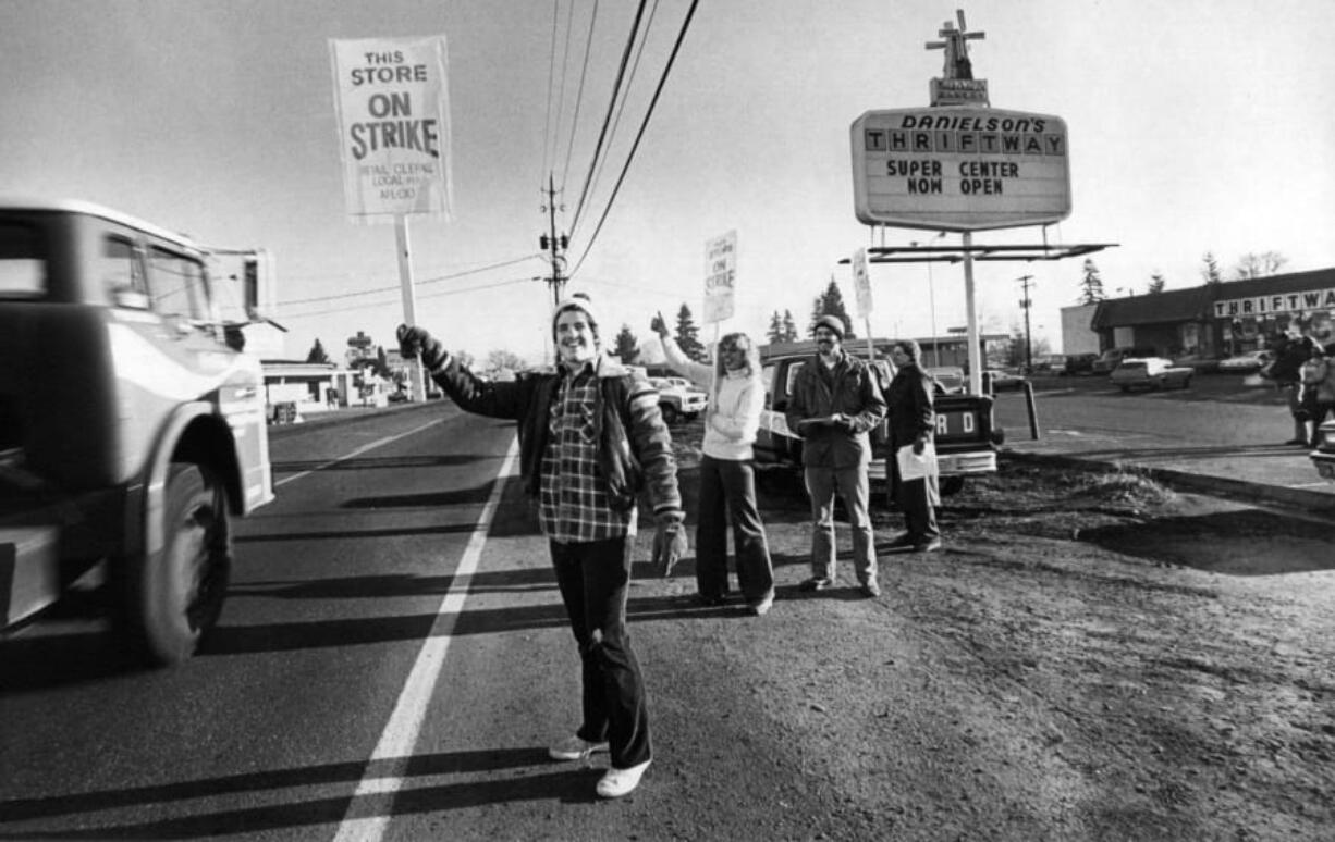 Randy Williams waves a strike sign at a passing truck outside a grocery store on Fourth Plain Boulevard and 109th Avenue in December 1980. Williams was participating in a retail workers strike.