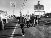 Randy Williams waves a strike sign at a passing truck outside a grocery store on Fourth Plain Boulevard and 109th Avenue in December 1980. Williams was participating in a retail workers strike.