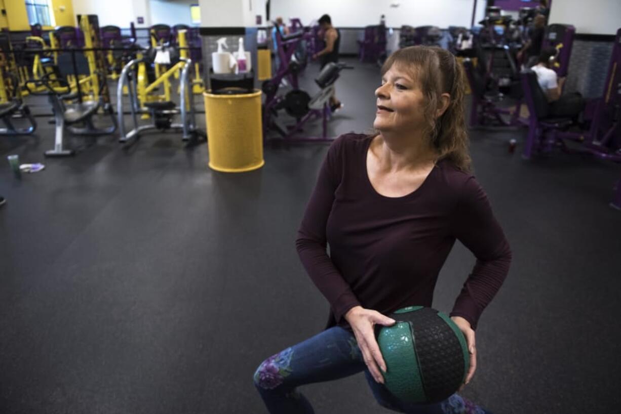 Kris Houston uses a medicine ball to work out at Planet Fitness in Hazel Dell. Houston has started working out four to five times a week since entering the Washington State University Clark County Extension Diabetes Prevention Program last year.