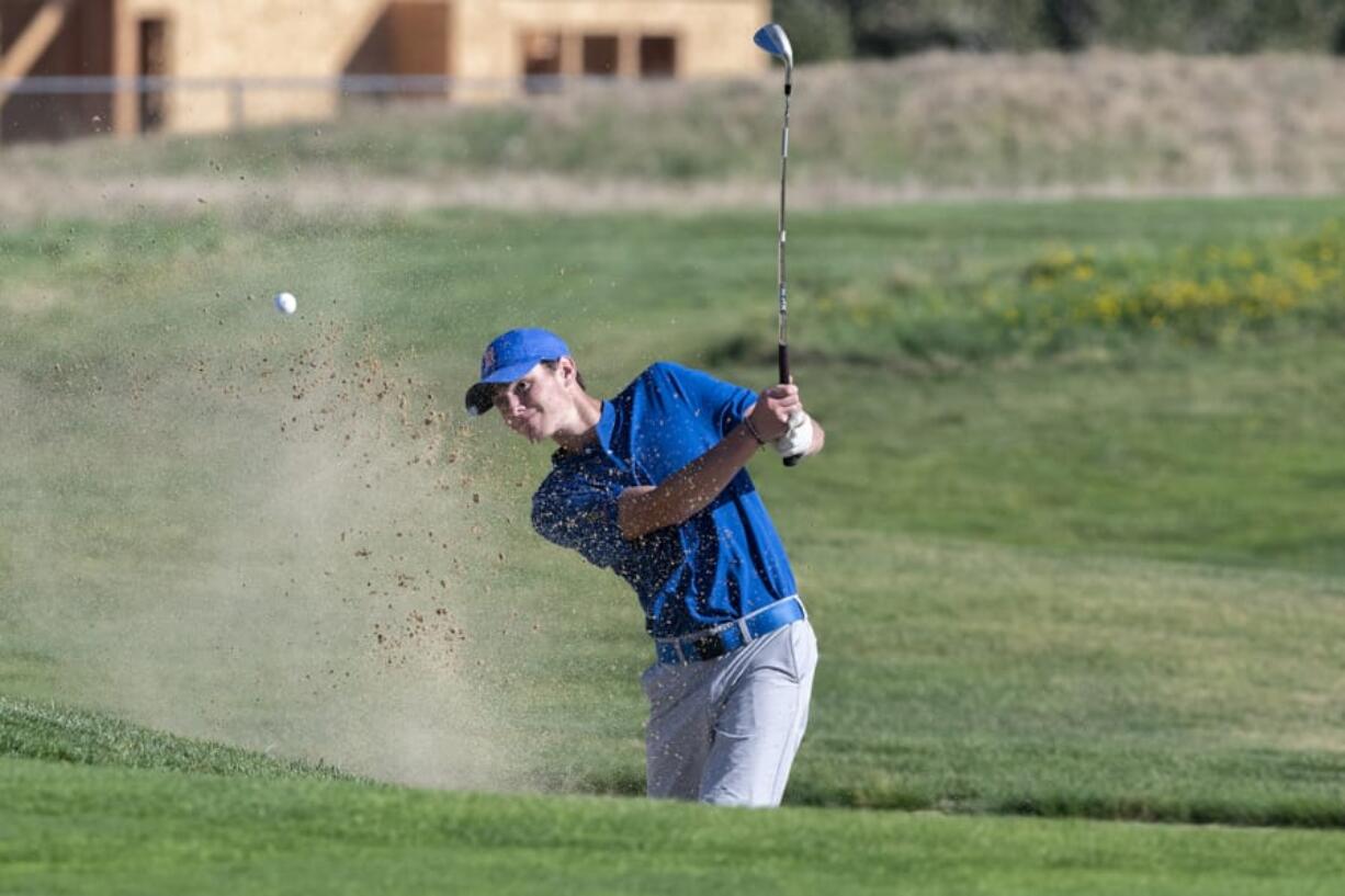 Ridgefield’s Caden Whitsitt punches a ball out of the sand bunker on the fourth hole at Tri-Mountain Golf Course on Tuesday, the first day of the high school fall sports season.