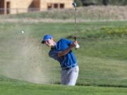 Ridgefield’s Caden Whitsitt punches a ball out of the sand bunker on the fourth hole at Tri-Mountain Golf Course on Tuesday, the first day of the high school fall sports season.