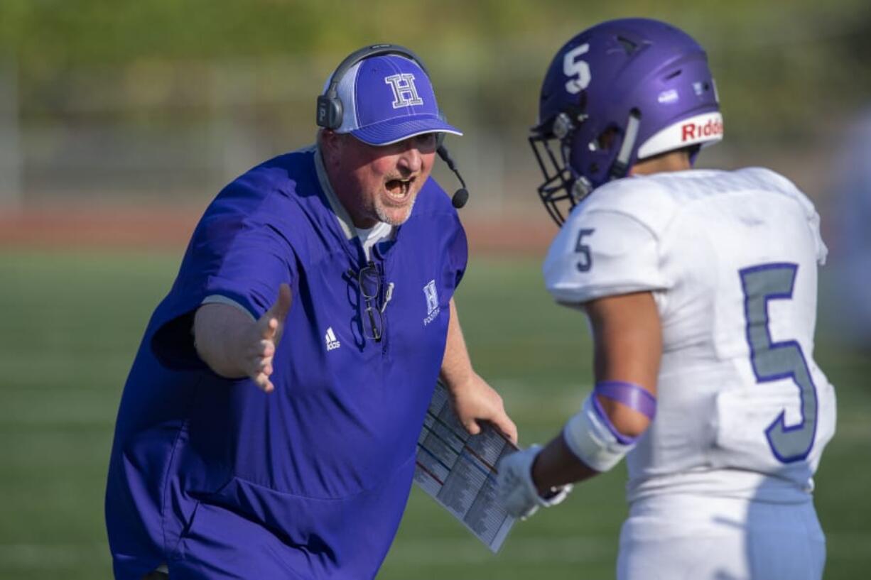 Heritage head coach Dennis Moody celebrates a touchdown with Isaac Roa (5) during the Timberwolves’ season opener at McKenzie Stadium on Friday evening.