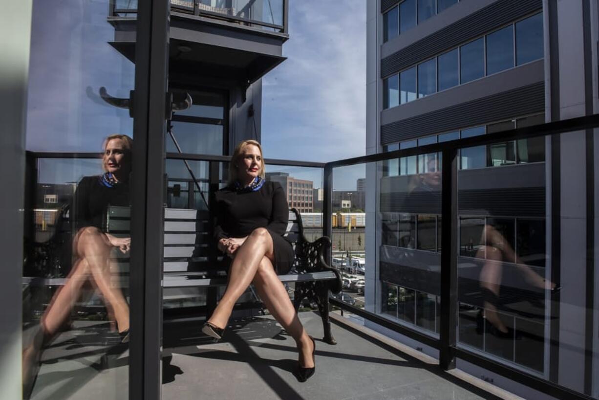 Kimberly Thornbury sits on a balcony at The Rediviva on Wednesday. She relocated from New York City and works in the building next door.