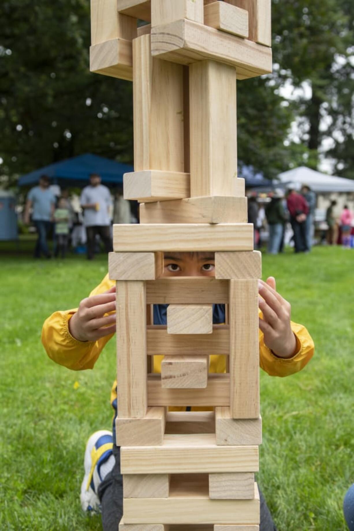 Ethan Chu, 10, uses every last block to complete his Jenga tower during the Fourth Plain Multicultural Festival at Evergreen Park in Vancouver on Saturday, Sept. 7.