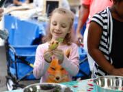 Lilyana Hobbs, 7, of Vancouver works on her vegetable creation Sunday at the Produce Pals program tent at the Vancouver Farmers Market.