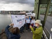 A group from Southwest Washington meets a group from Oregon on Monday night on the Interstate 5 Bridge. The demonstration organized by the left-leaning Indivisible activist group is seeking to reduce the budgets for U.S. Immigration and Customs Enforcement as well as U.S. Customs and Border Protection.