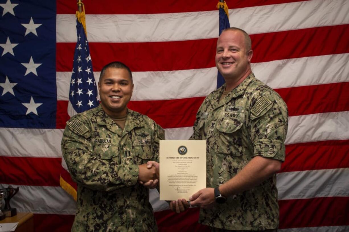 Navy Counselor First Class Derrick Wolf, right, re-enlists for five more years of service in the U.S. Navy. U.S.