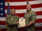 Navy Counselor First Class Derrick Wolf, right, re-enlists for five more years of service in the U.S. Navy. U.S.