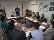 Instructor Ruslan Revutsky of Lutheran Community Services Northwest, standing, reviews the three branches of U.S. government while leading a citizenship class Monday morning. The Vancouver office is celebrating its 25th anniversary on Thursday.