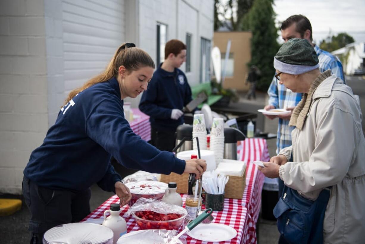 Clark County Fire Department cadet Danielle Haner, left, helps Deann Blakeman during a Superpower Pancake Feed at North County Community Food Bank Thursday. The food bank was the top fundraiser at this year&#039;s Give More 24.