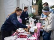 Clark County Fire Department cadet Danielle Haner, left, helps Deann Blakeman during a Superpower Pancake Feed at North County Community Food Bank Thursday. The food bank was the top fundraiser at this year&#039;s Give More 24.