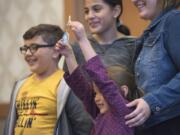 Tony Guzman, 7, from left, Ely Guzman, 11, Anabelle Guzman, 5, and their mother Casey Rice celebrate getting their house key during the Evergreen Habitat for Humanity&#039;s Raising the Roof benefit breakfast at the Hilton Vancouver Washington.
