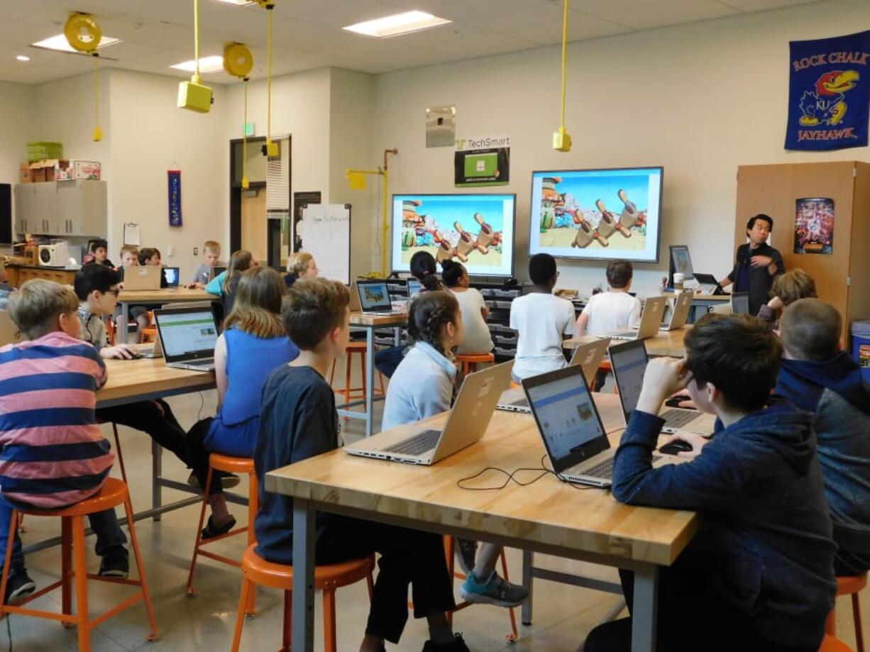 Sunset Ridge Intermediate School teacher Nam Nguyen shows fifth-graders the dance animation sequence during a programming assignment in his computer science class.