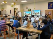 Sunset Ridge Intermediate School teacher Nam Nguyen shows fifth-graders the dance animation sequence during a programming assignment in his computer science class.