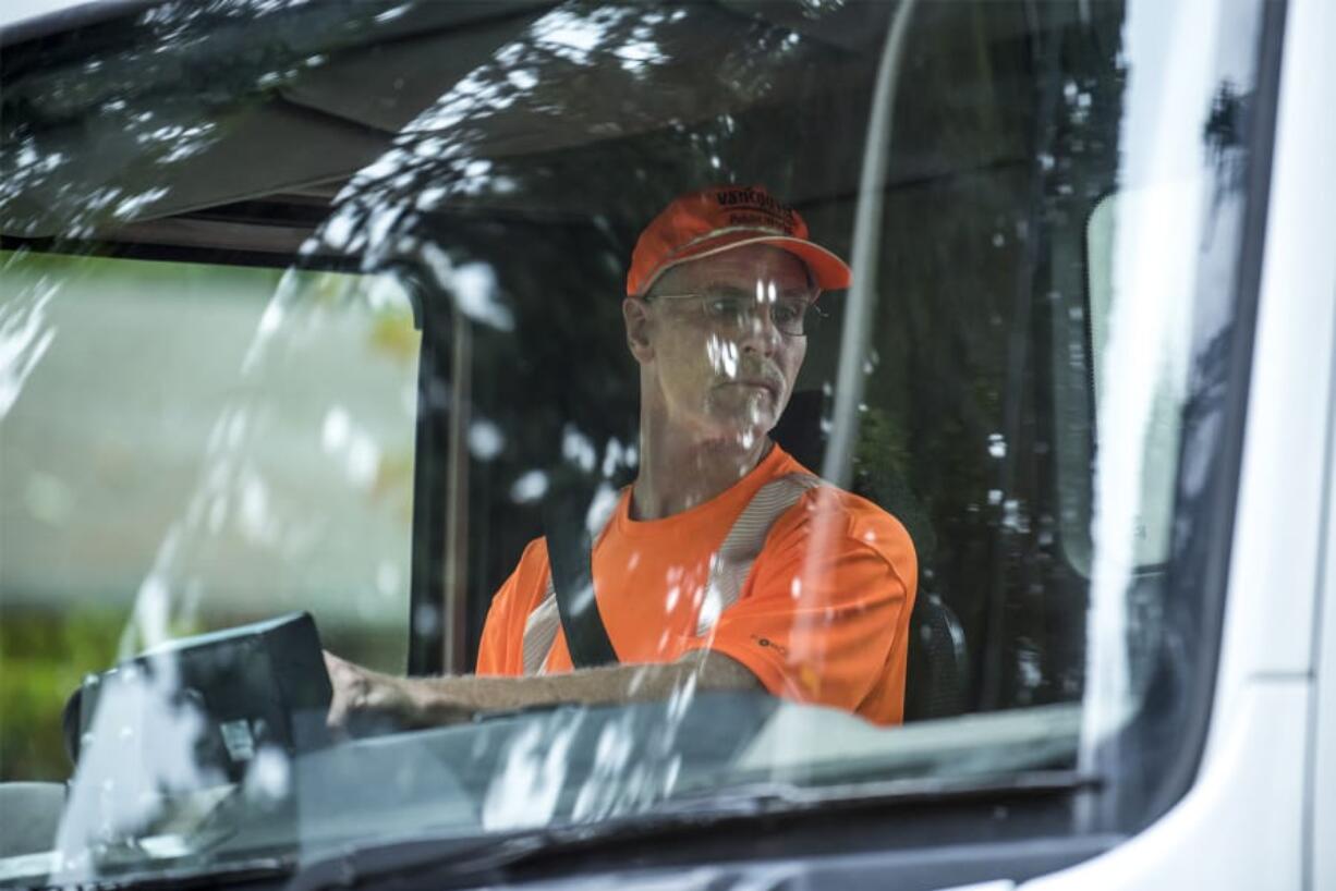 Bill Lamkin, a maintenance worker with Vancouver Public Works, checks his mirrors while driving a vacuum intake street sweeper through the DuBois Park neighborhood. Lamkin has worked for the city for the department for 12 years, rotating on and off sweeping jobs to other maintenance tasks.