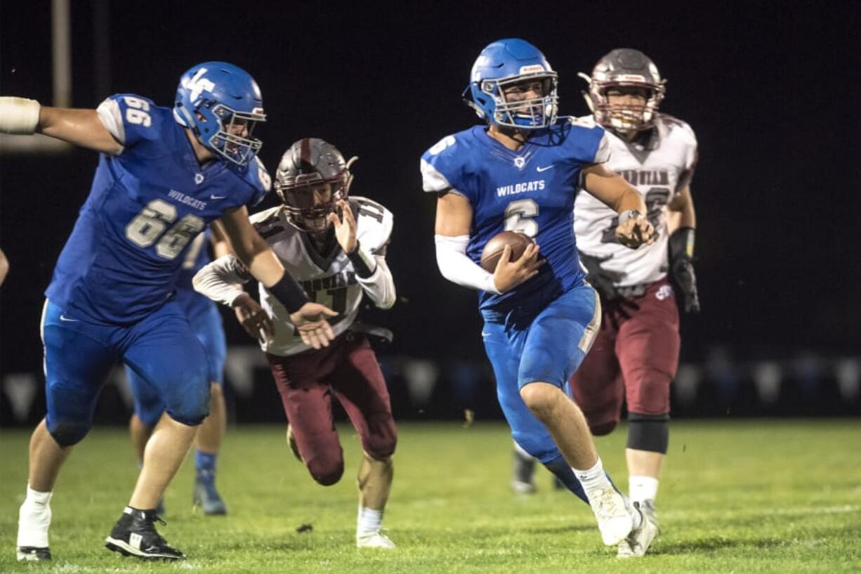 La Center Quarterback Tom Lambert scrambles under pressure from Hoquiam during a game at La Center High School on Friday night, Sept. 20, 2019.