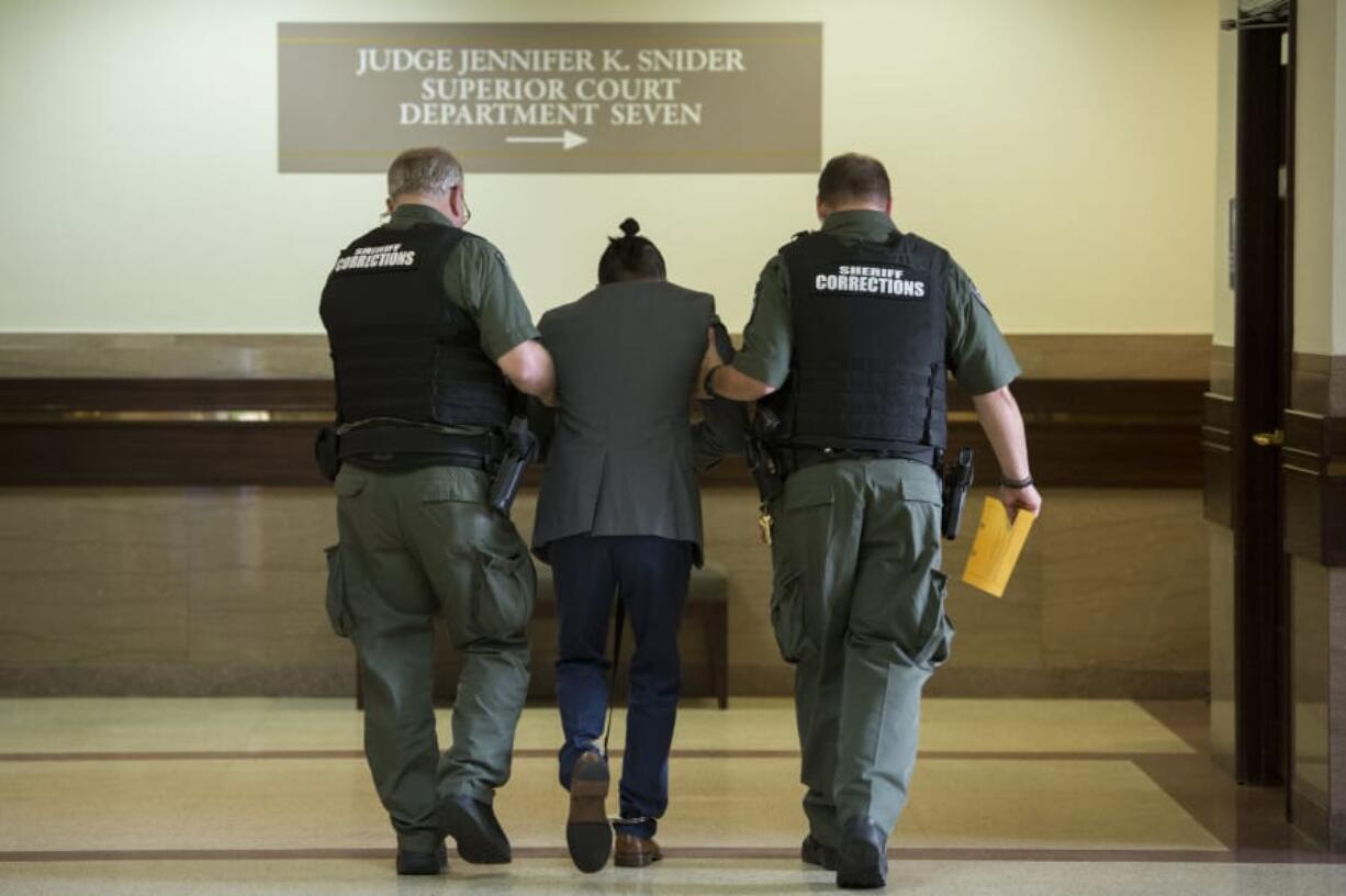 Corrections deputies assist Mitchell Heng as he is overcome with emotion after the guilty verdict in his murder trial in Clark County Superior Court on Thursday evening.