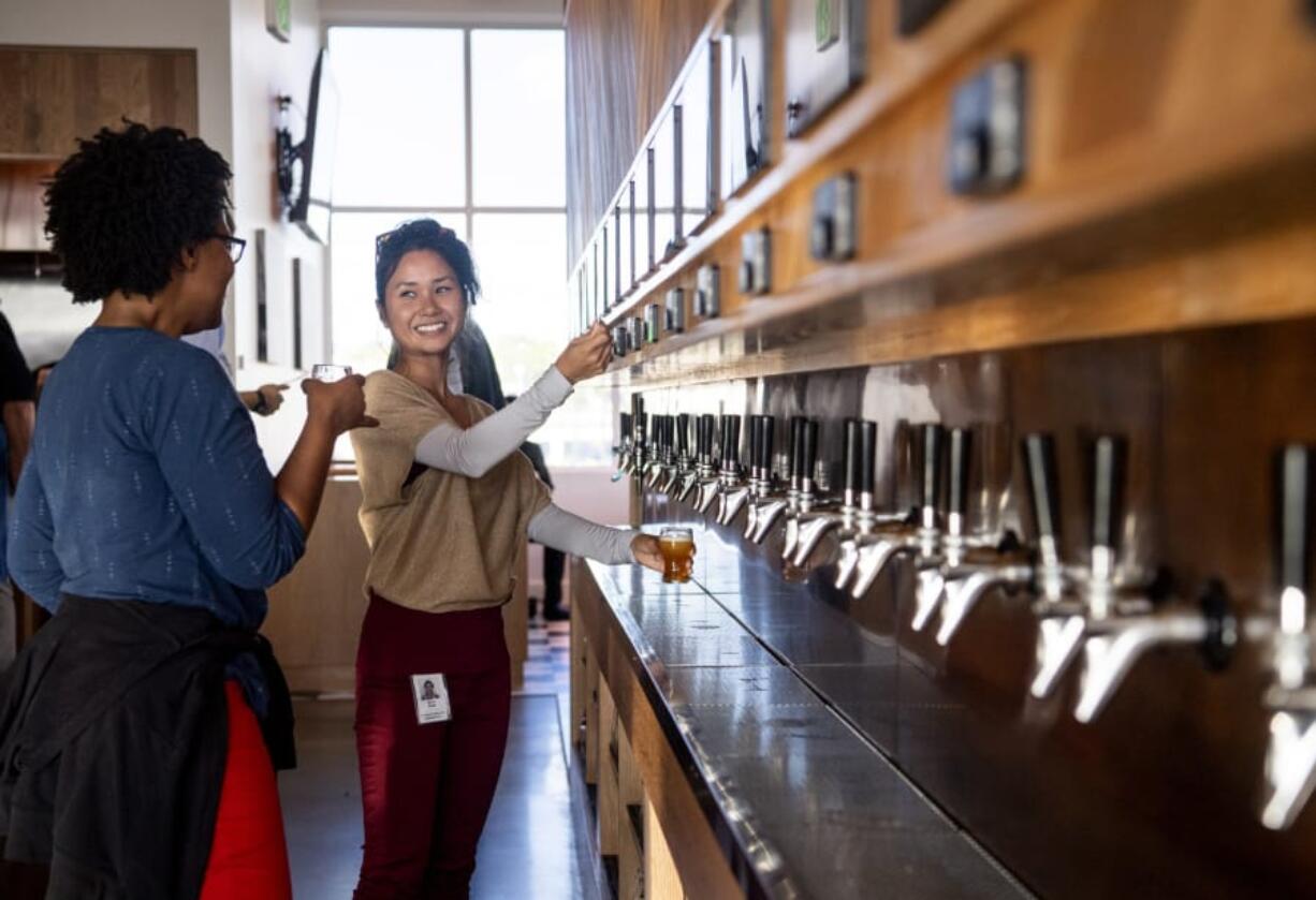 Lisa Harris of Vancouver, left, and Erica Nuth of Beaverton, Ore., taste different beers at the newest Waterfront Vancouver restaurant, Barlow&#039;s Public House. Barlow&#039;s has one of the first self-serve tap walls in the Portland area. Customers are given a card that is connected to their bill, and each pour is calculated and tallied.