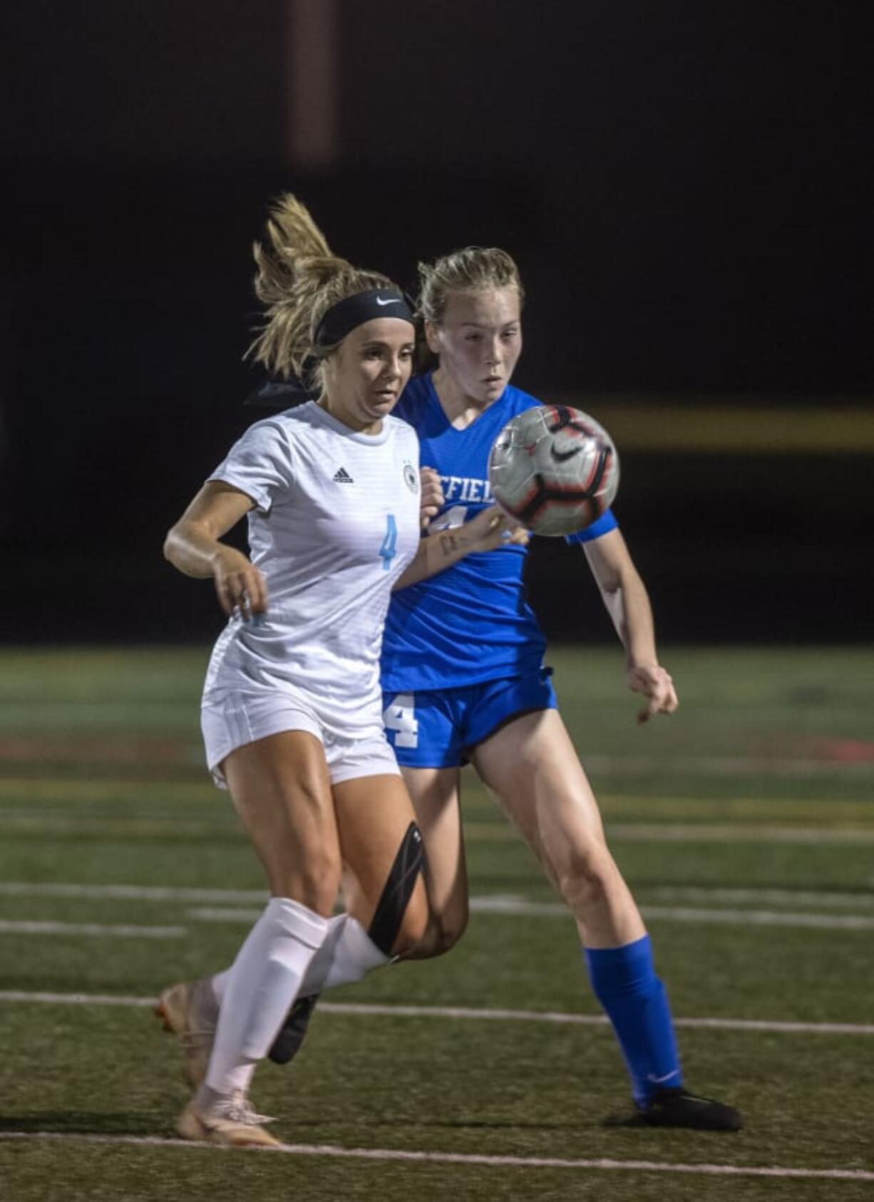 Hockinson's Kati Waggoner (4) and Ridgefield's Ella Krause (14) fight for possession during Tuesday night's game in Ridgefield on Sept. 24, 2019. Ridgefield won 4-0.