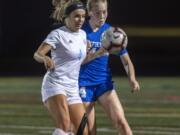 Hockinson's Kati Waggoner (4) and Ridgefield's Ella Krause (14) fight for possession during Tuesday night's game in Ridgefield on Sept. 24, 2019. Ridgefield won 4-0.