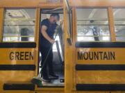 Debbie Proctor sweeps out dirt and pine needles from her bus after dropping off her last student from Green Mountain Elementary School in Woodland.