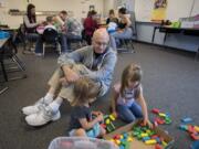 Ava West, 2, of Battle Ground, from left, joins her grandfather, Bill Jackson, and classmate Emma Betka, 3, as they play with blocks Wednesday afternoon at Daybreak Primary School. The activity was part of Let's Play and Learn Together, a free weekly drop-in program hosted by Battle Ground Public Schools for students age 5 or younger.