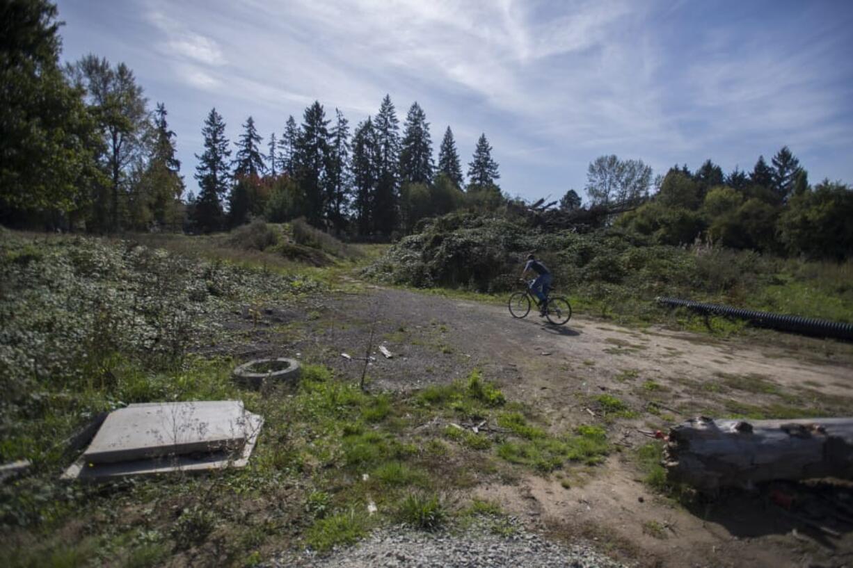 A cyclist rides through vacant land at 306 S.E. Clark Ave. in Battle Ground that Vancouver Housing Authority plans to buy for the construction of an 80-unit development.