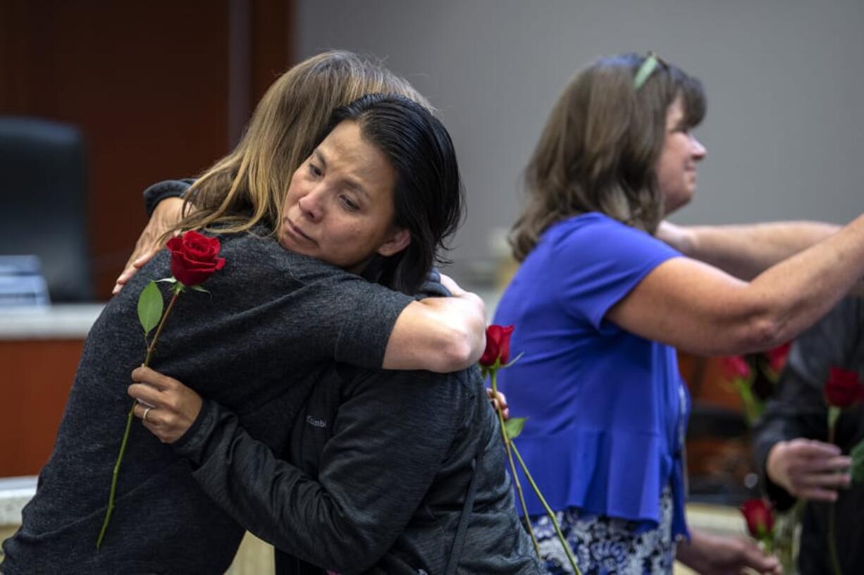 Victims advocate Amy Harlan, left, embraces Savdey Harig of Vancouver after handing her a rose during the annual Day of Remembrance for Homicide Victims at the Public Service Center on Monday. Harig and her husband, Tom, lost their son, Andrew Harig, in August after he was struck by an allegedly intoxicated driver.